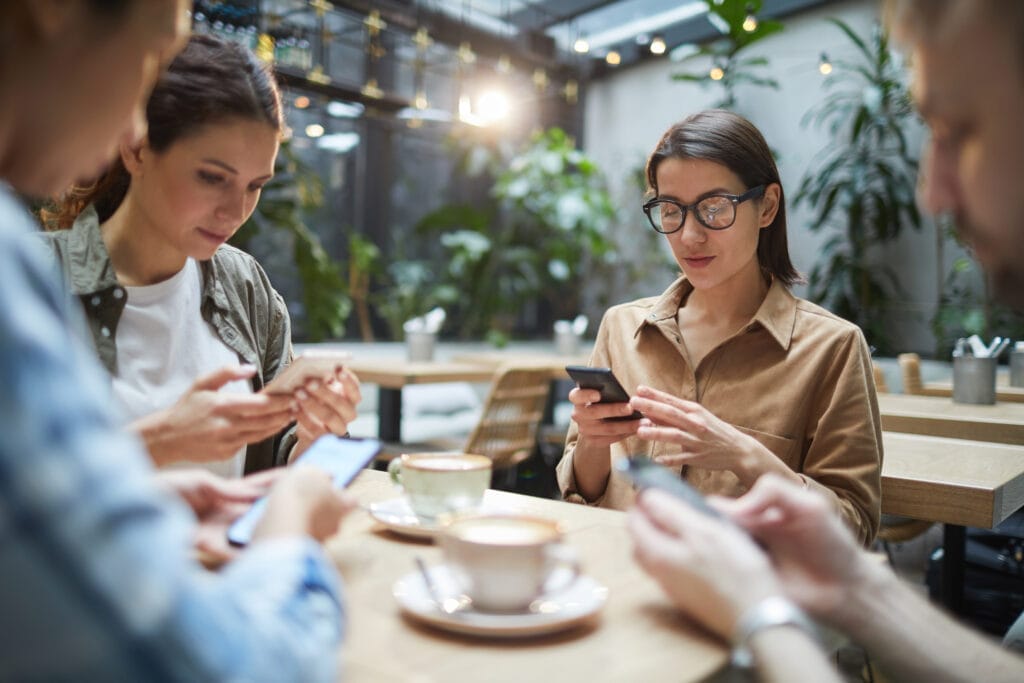 Group of young business professionals at lunch on their social media profiles